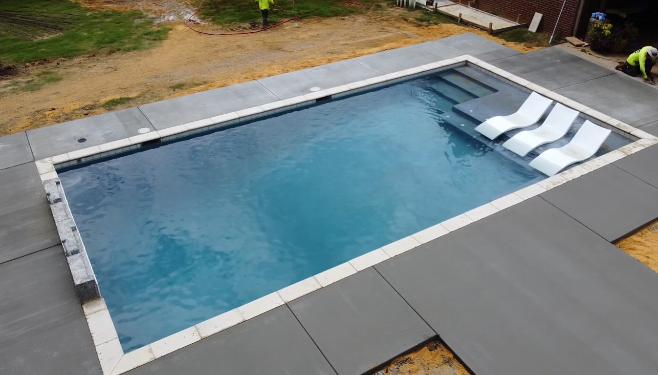 Professional concrete pool deck installation around residential swimming pool